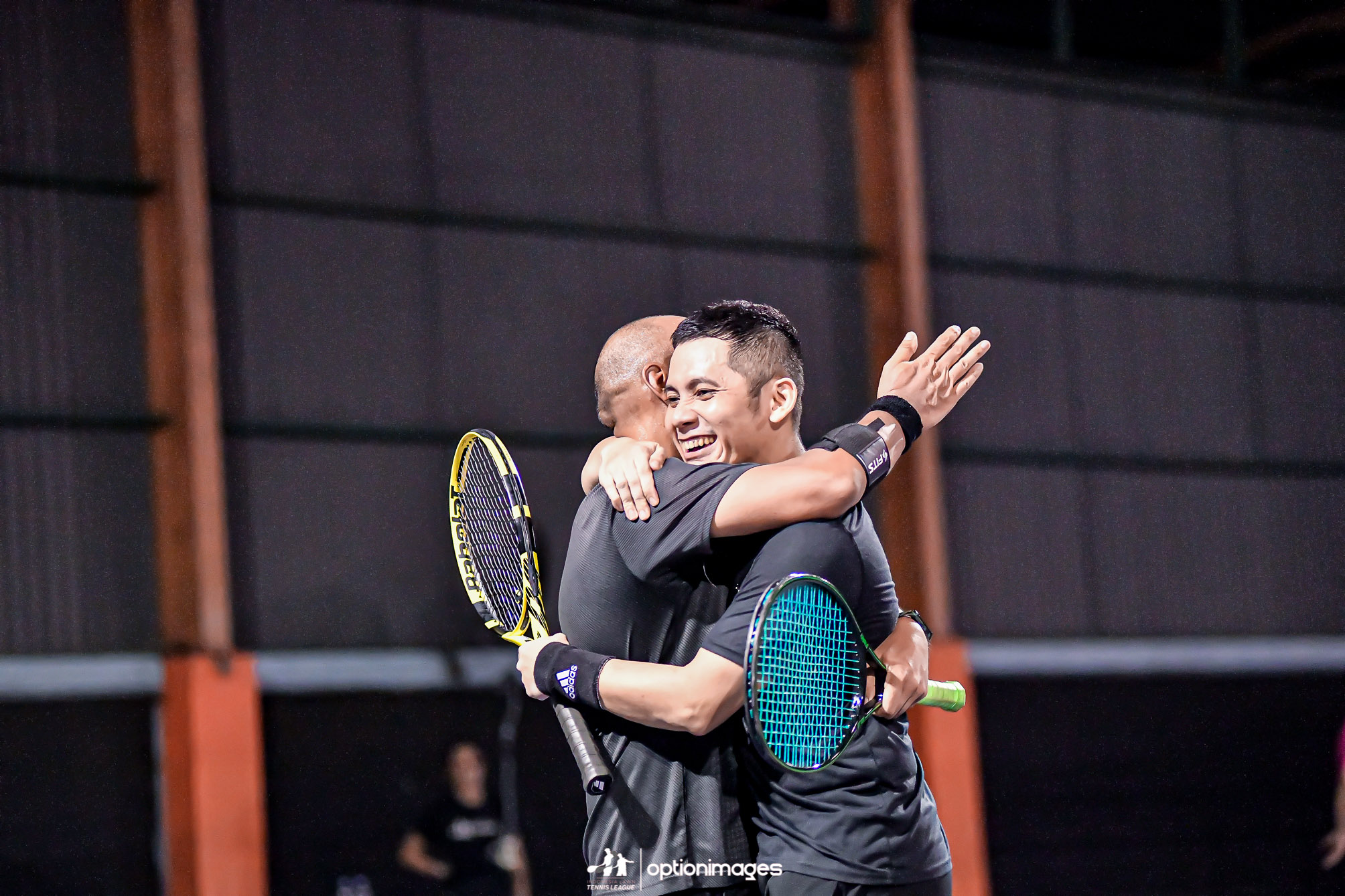 Doubles partners embracing after winning the beginner doubles championship.