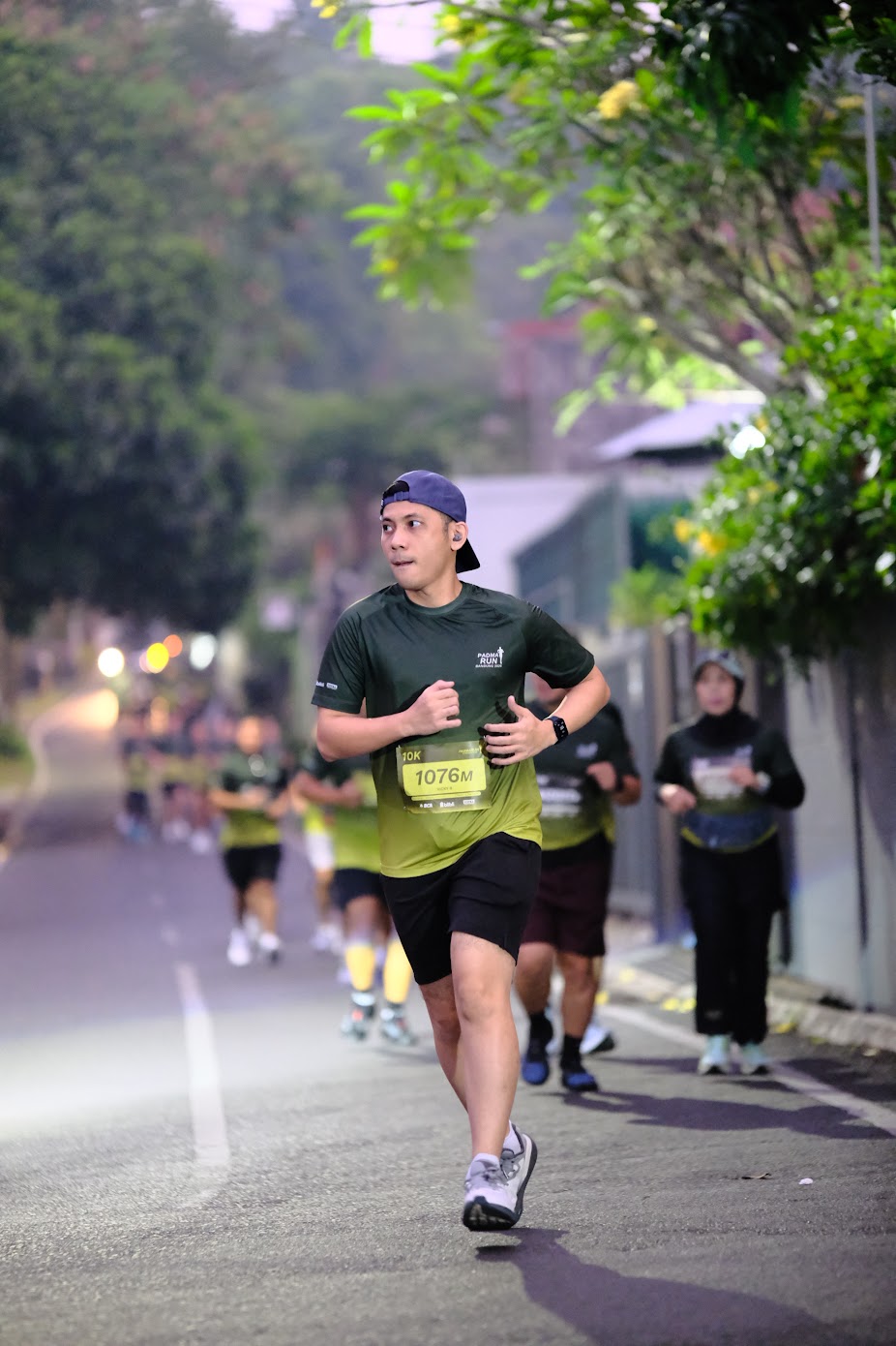 A runner wearing bib 1076M alongside other participants at Padma Run Bandung.